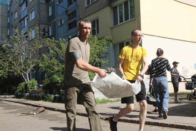 Archivo - Arquivo - 26 de abril de 2025, Kamianske, região de Dnipropetrovsk, Ucrânia: Homens removem os escombros do lado de fora de um bloco de apartamentos de nove andares atingido por um drone russo em Kamianske, região de Dnipropetrovsk, Ucrânia, em 