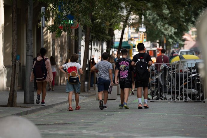 Archivo - Uns nens caminant després de l'escola a Barcelona
