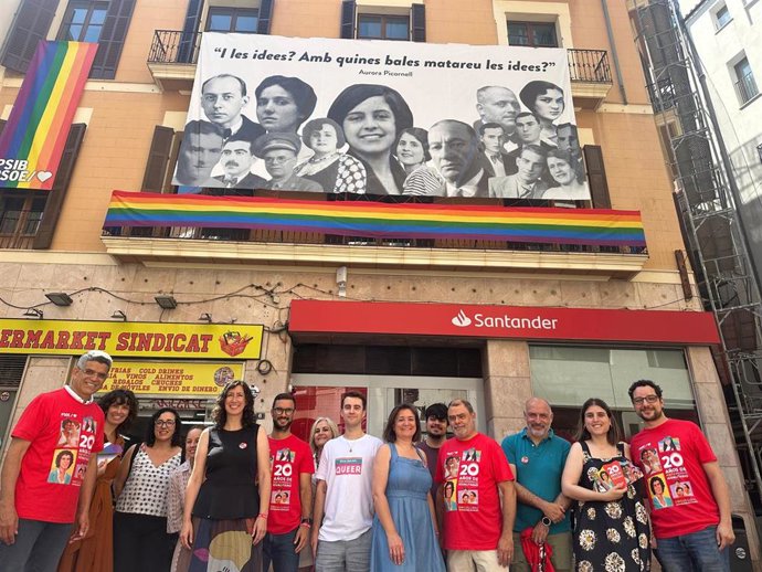 Miembros del PSIB posan frente a la sede del partido, que luce una bandera LGTBI en el balcón con motivo del día del Orgullo.