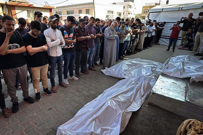25 de junho de 2025, Territórios Palestinos, Deir El-Balah: Palestinos rezam sobre os corpos de pessoas que foram mortas durante um ataque israelense, no Hospital dos Mártires de Al-Aqsa em Deir al-Balah, Faixa de Gaza. Foto: Ahmed Ibrahim/APA Images via 