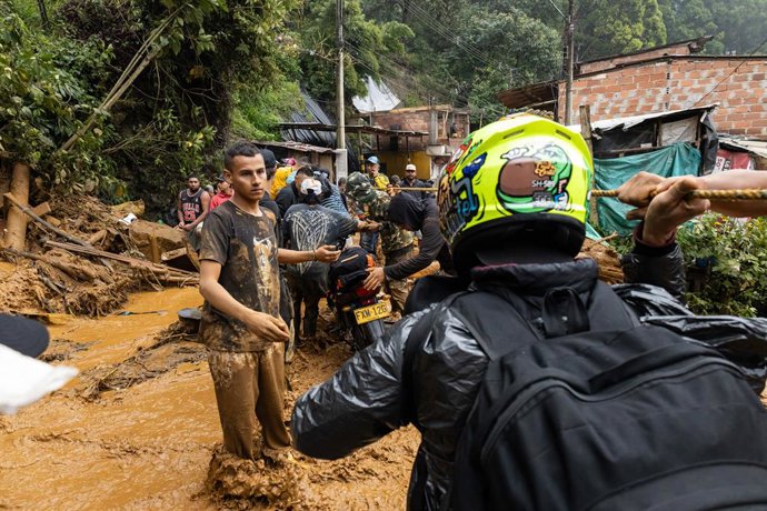 24 de junho de 2025, Bello, Antioquia, Colômbia: Membros da comunidade e da defesa civil participam de missões de busca e resgate no município de Bello, perto de Medellín, Colômbia, depois que um deslizamento de terra provocado por fortes chuvas matou 10 