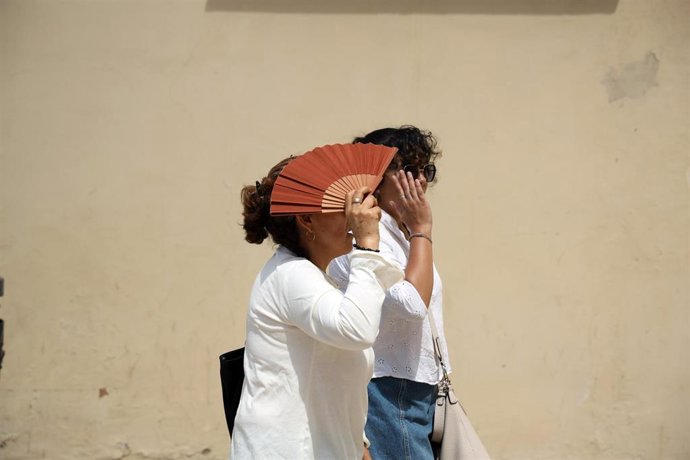 Varias personas se protegen del sol 