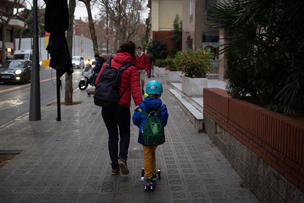 Archivo - Una mujer lleva de la mano a un niño a clase, en una imagen de archivo