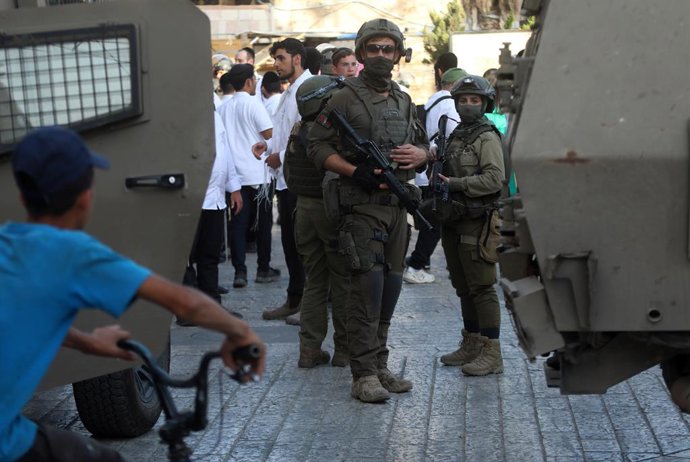 HEBRON, June 1, 2025 -- Colonos israelenses são vistos sob forte proteção das forças israelenses na Cidade Velha de Hebron, no sul da Cisjordânia, em 31 de maio de 2025.