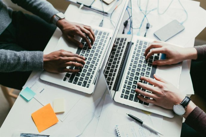 Archivo - Imagen de archivo de dos personas que trabajan con ordenadores.