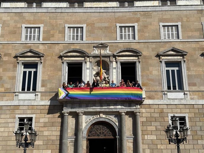 El conseller de la Presidencia de la Generalitat, Albert Dalmau, y la consellera de Igualdad y Feminismo, Eva Menor, despliegan este sábado una bandera LGTBIQ+ en el balcón del Palau de la Generalitat con motivo del Día Internacional del Orgullo.