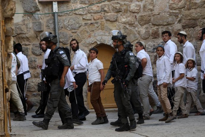 HEBRON, June 1, 2025 -- Colonos israelenses são vistos sob forte proteção das forças israelenses na Cidade Velha de Hebron, no sul da Cisjordânia, em 31 de maio de 2025.