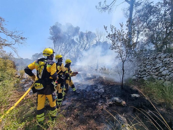 Bomberos del Ibanat durante el incendio forestal cerca de cala Macarella