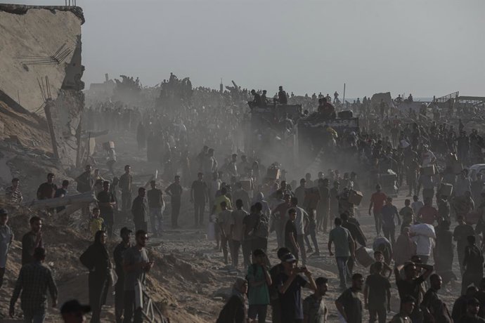 16 de junho de 2025, Cidade de Gaza, Faixa de Gaza, Território Palestino: Palestinos carregam pacotes de alimentos, distribuídos pela "Gaza Humanitarian Relief Foundation", enquanto as pessoas lutam contra a fome durante os contínuos ataques israelenses n