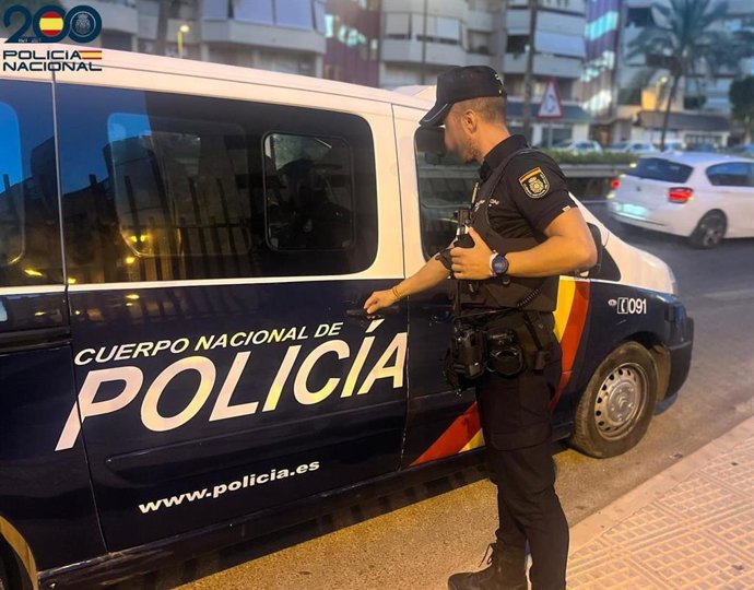 Un agente de la Policía Nacional junto  a un furgón policial