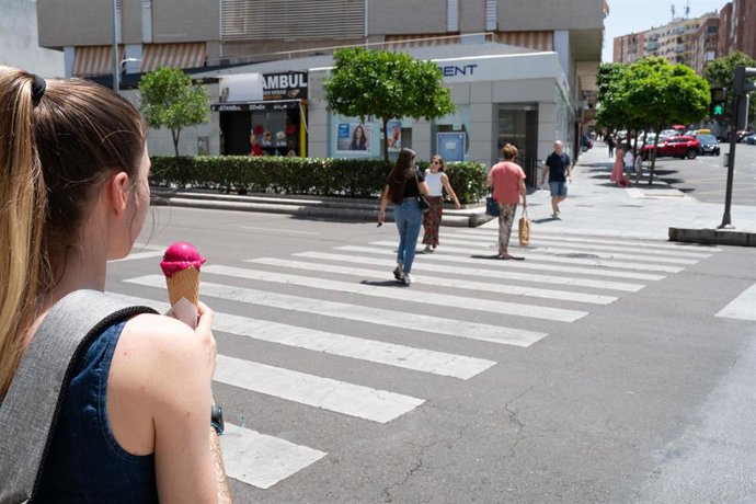 Archivo - Una mujer camina con un helado en Badajoz. Imagen de archivo