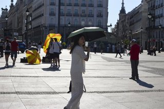 Varias personas pasean por la calle, a 16 de junio de 2025, en Madrid (España). La Agencia Estatal de Meteorología (AEMET) activa el aviso amarillo en Madrid este lunes y martes por temperaturas que superarán los 36 grados en varias zonas de la región. El