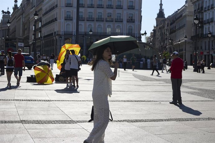 Varias personas pasean por la calle, a 16 de junio de 2025, en Madrid (España). La Agencia Estatal de Meteorología (AEMET) activa el aviso amarillo en Madrid este lunes y martes por temperaturas que superarán los 36 grados en varias zonas de la región. El