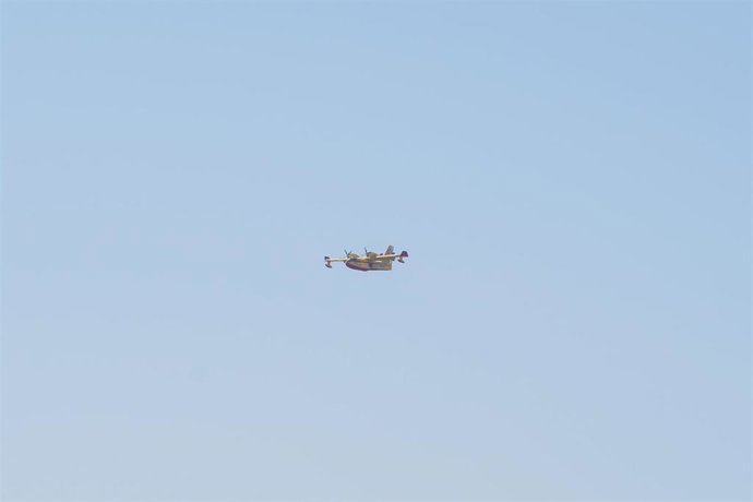 Archivo - Un avión sobrevuela un incendio.