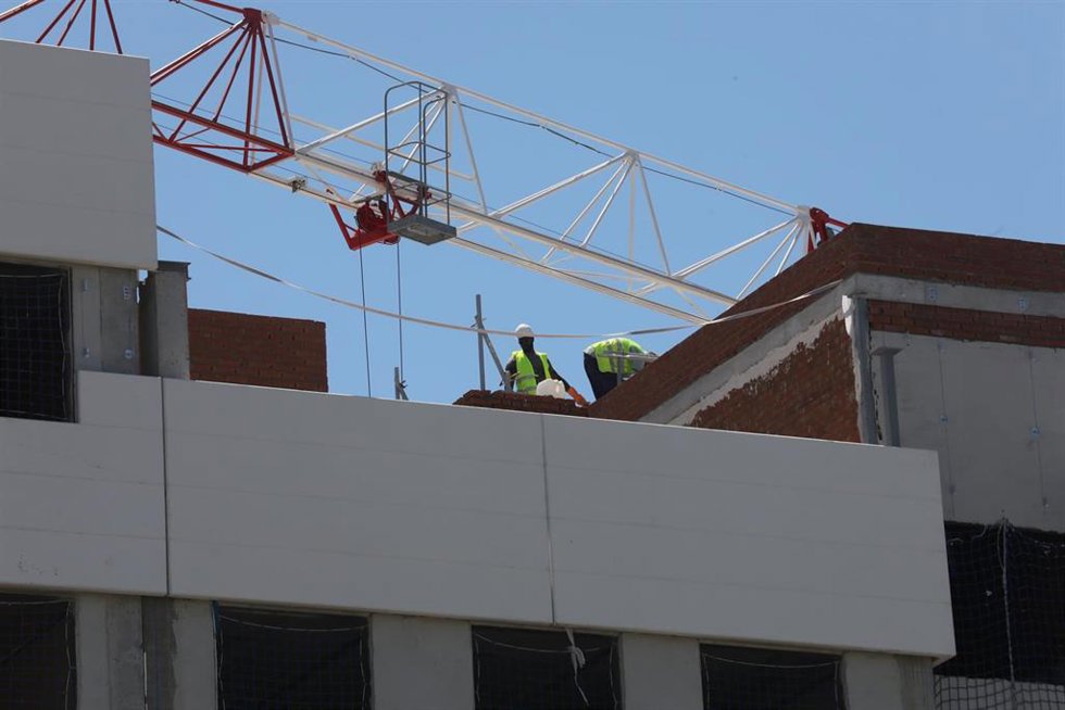 Archivo - Dos obreros trabajan en la construcción de un edificio de viviendas en Madrid