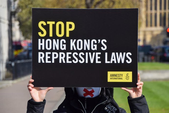 Archivo - 19 de março de 2025, Londres, Inglaterra, Reino Unido: Ativistas da Anistia Internacional do Reino Unido e ativistas de Hong Kong usando máscaras estão do lado de fora do parlamento no primeiro aniversário da aprovação da lei do Artigo 23 em Hon