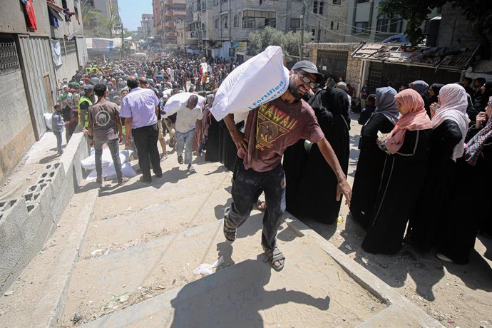 GAZA, June 26, 2025 -- Palestinos se reúnem para receber ajuda alimentar em um ponto de distribuição de assistência alimentar na Cidade de Gaza, em 26 de junho de 2025.
