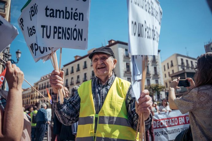 Archivo - Un manifestante con pancartas durante la manifestación contra las reformas de pensiones llevadas a cabo por el Gobierno en la presente legislatura, a 15 de abril de 2023, en Madrid 