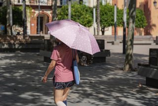 Archivo - Una mujer con sombrilla y ropa veraniega. A 05 de julio de 2024, en Sevilla (Andalucía, España). Andalucía afronta este martes la primera jornada de la segunda ola que se extenderá hasta el jueves 25 de julio, tras la finalización de la primera 
