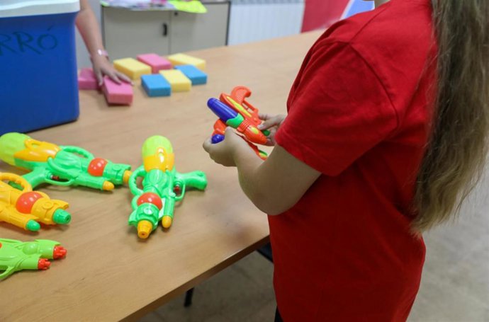 Archivo - Una niña con varias pistolas de agua 