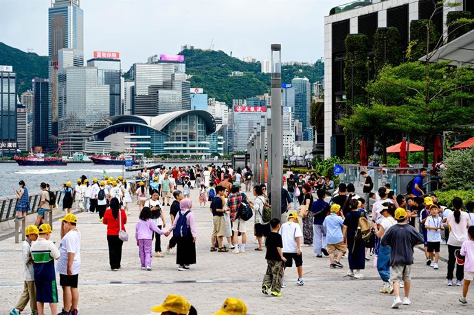 1º de julho de 2025, Hong Kong, China: Pessoas passeiam pelo calçadão à beira-mar no aniversário da transferência de controle de Hong Kong para a China em 1997. Este ano marca o 28º aniversário do retorno de Hong Kong à China.