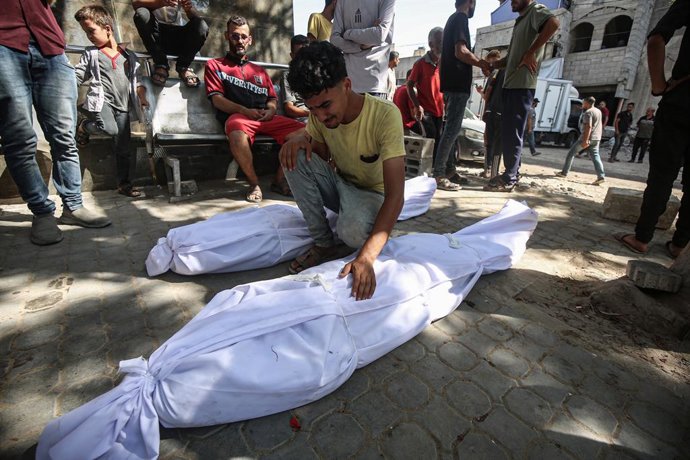 30 June 2025, Palestinian Territories, Gaza City: Relatives of Palestinians who lost their lives in an Israeli bombing on the Gaza City beach, mourn outside Al-Shifa Hospital. Photo: Omar Ashtawy/APA Images via ZUMA Press Wire/dpa