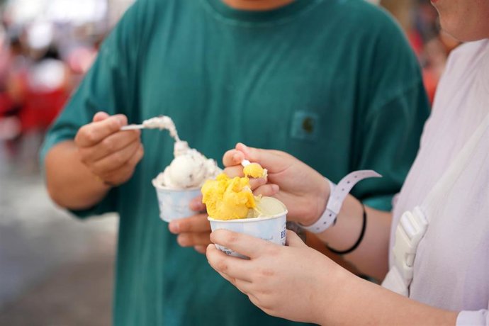 Archivo - Varias personas se toman un helado.