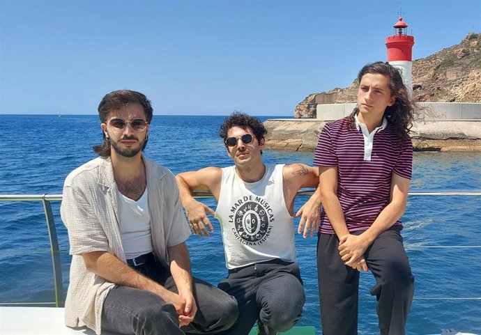 Daniel Sánchez (guitarra), Jota Mercader (batería) y Antonio García, (cantante) durante el recorrido en catamarán por el puerto de Cartagena
