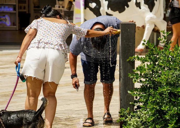Archivo - Arxiu - Un home es refresca en una font a València, en una imatge d'arxiu