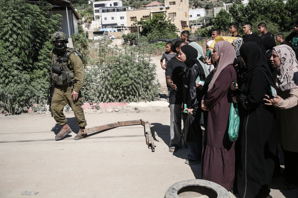 Un soldado israelí establece un control para mujeres palestinas que intentan entrar en el campo de regugiados de Tulkarm en Cisjordania