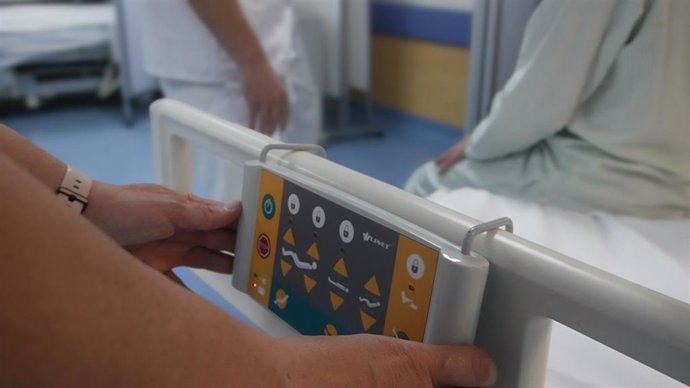 Celadores del Hospital Virgen Macarena realizando maniobras en una camilla.