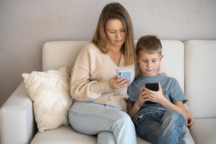Mãe e filho usando um smartphone.