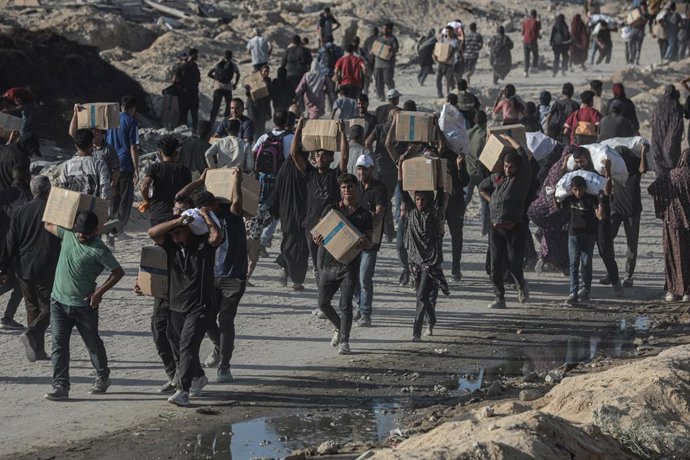 16 June 2025, Palestinian Territories, Gaza City: Palestinians carry food parcel, distributed by 'Gaza Humanitarian Relief Foundation' as people struggle with hunger amid the ongoing Israeli attacks on Gaza City. Photo: Omar Ashtawy/APA Images via ZUMA Pr