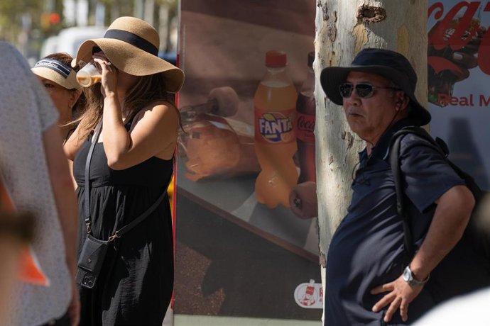 Archivo - Varias personas pasean por la ciudad, a 17 de julio de 2024, en Barcelona.