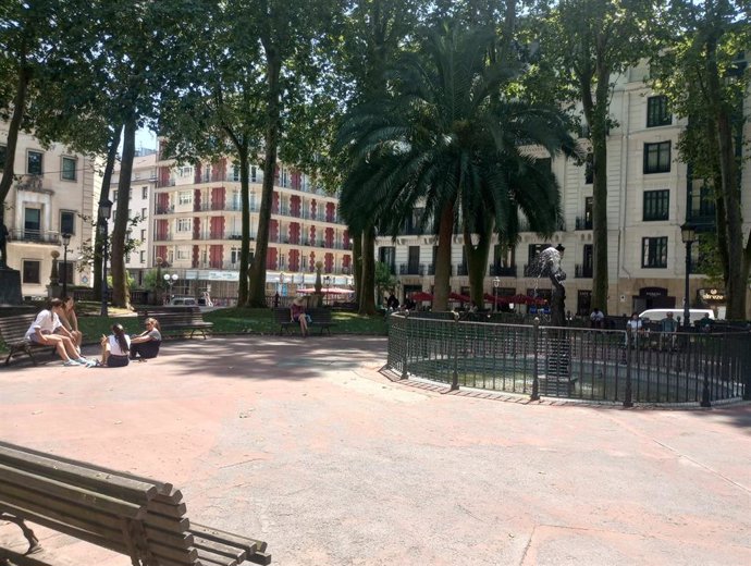 Gente en Bilbao se resguarda del sol en el parque de Jardines de Albia