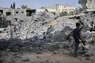 July 1, 2025, Dair El-Balah, Gaza Strip, Palestinian Territory: Palestinians inspect the rubble of the Al-Aimawi family's home, destroyed by Israeli airstrikes in Al-Zawaideh, central Gaza Strip, on Tuesday, July 1, 2025