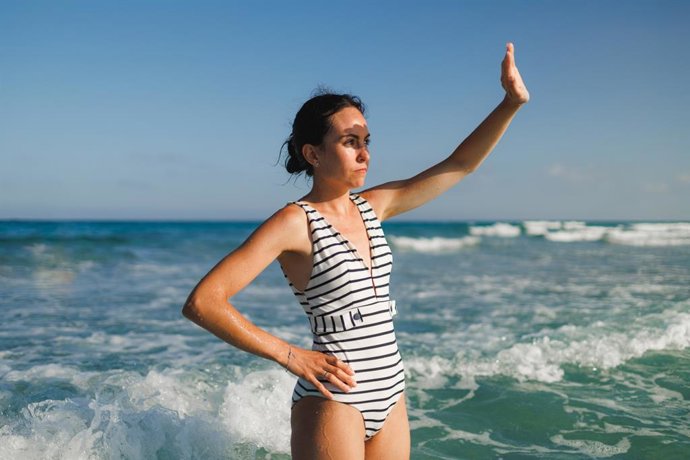 Archivo - Mujer joven que protege sus ojos de la luz solar