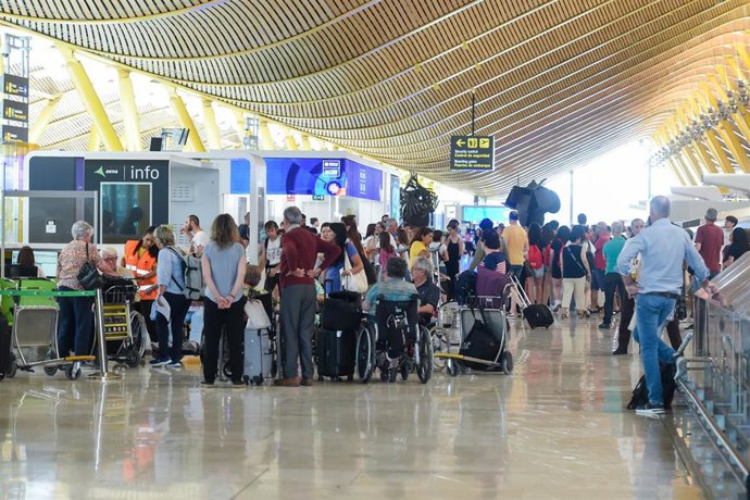 Pasajeros esperan en la entrada de la Terminal 4 de Barajas durante el colapso por falta de personal, a 2 de julio de 2025, en Madrid (España). 
