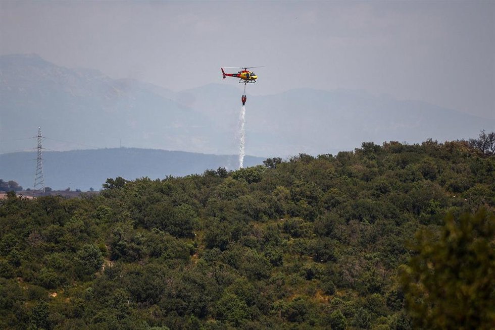 Helicópteros de bomberos tratan de apagar los restos del incendio en Torrefeta i Florejacs (Lleida)