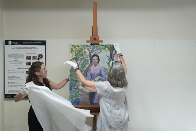 Les restauradores amb l'obra de Lola Anglada