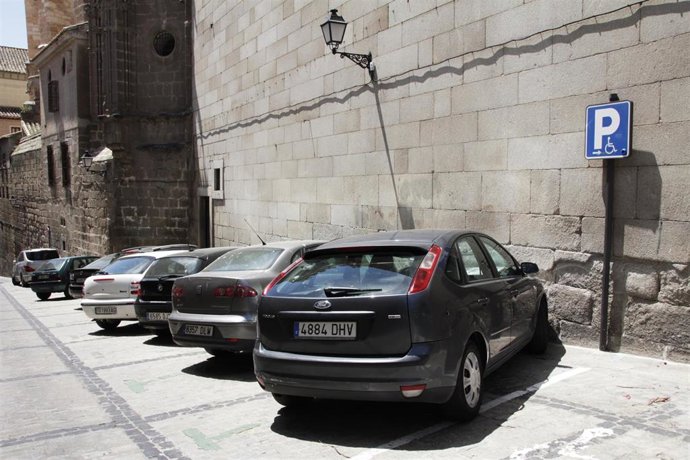 Archivo - Coches, coches aparcados, señal minusválidos