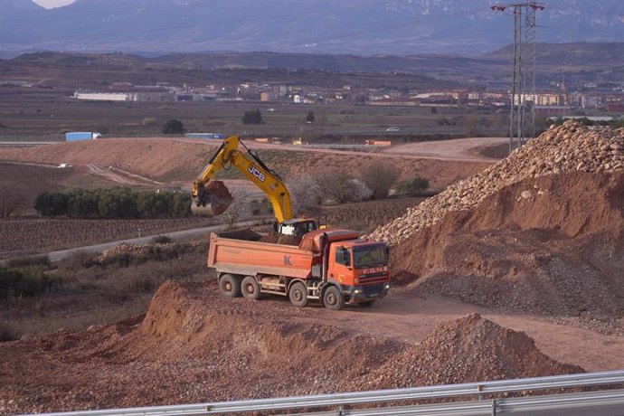 Archivo - Un camión y una máquina retroexcavadora en las obras de la Ronda Sur de Logroño