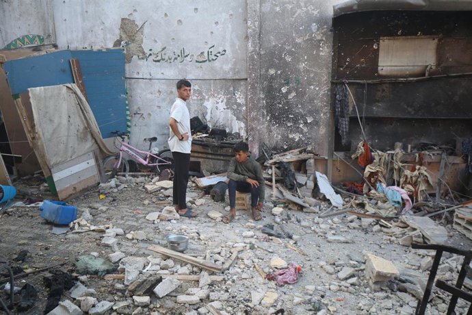 Jóvenes gazatíes en el lugar donde estaba la escuela Mustafa Hafez, que funcionaba como refugio de personas desplazadas, atacada por el Ejército de Israel