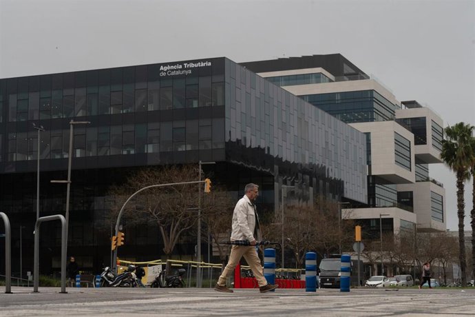 Archivo - Un hombre pasa delante de la sede de la Agencia Tributaria de Cataluña (ATC)