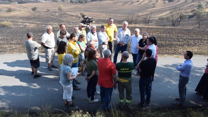 Archivo - El conseller de Agricultura, Ganadería, Pesca y Alimentación de la Generalitat, Òscar Ordeig, junto a afectados por el incendio.
