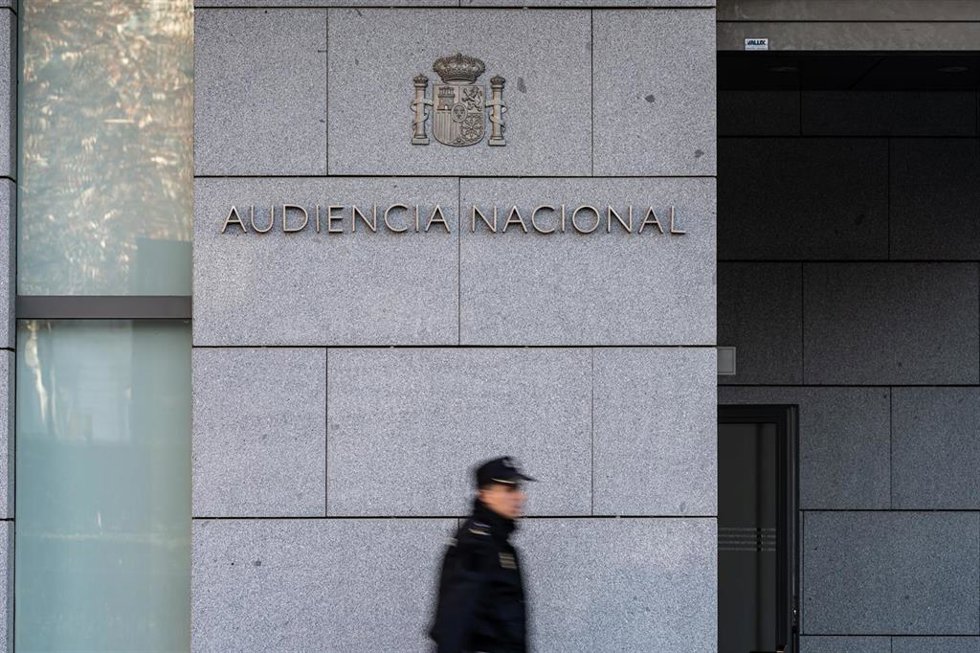 Archivo - Un agente de Policía Nacional camina frente a la Audiencia Nacional, en Madrid (España).