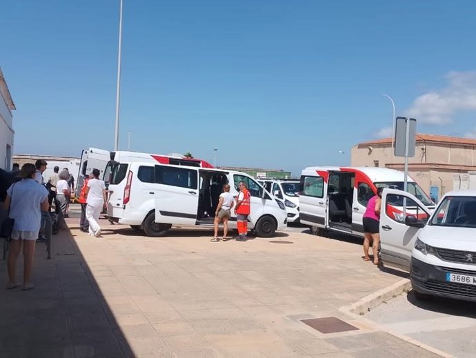 Vehículos preparados en el polideportivo para el traslado de los mayores al geriátrico de Facinas.