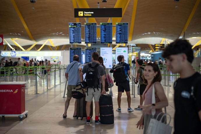 Varias personas observan las pantallas de información en el aeropuerto Adolfo Suárez Madrid-Barajas durante la primera operación salida del verano 2025, a 27 de junio de 2025, en Madrid (España). Aena estima que las aerolíneas han programado casi 1,4 mill