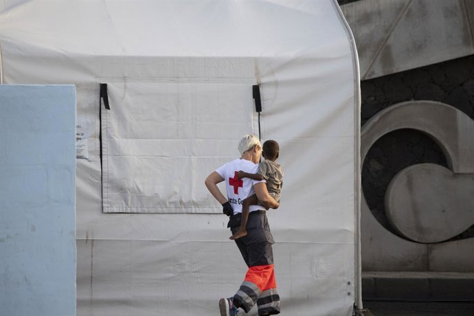 Archivo - Una persona de la Cruz Roja sostiene a un menor, en el Puerto de la Restinga, a 28 de noviembre de 2024, en El Hierro, Santa Cruz de Tenerife, Tenerife, Canarias (España). Un cayuco con 136 personas a bordo ha sido localizado a 10 millas de la I
