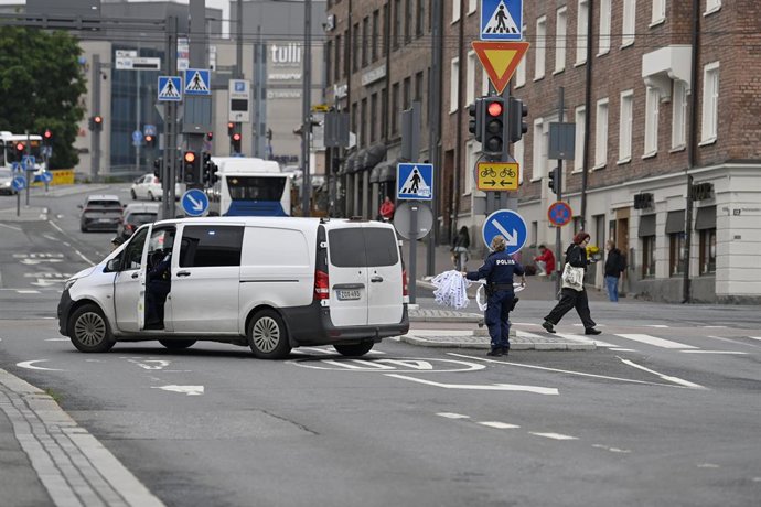 03 July 2025, Finland, Tampere: A police officer removes a cordon outside the Ratina shopping centre, where several people have been stabbed. One suspect has been arrested in connection with the attack. Photo: Saara Peltola/Lehtikuva/dpa